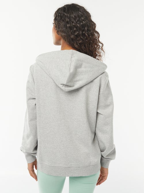 Damesvest van sweatstof met rits en capuchon - Kiabi Damesvest van sweatstof met rits en capuchon - Kiabi