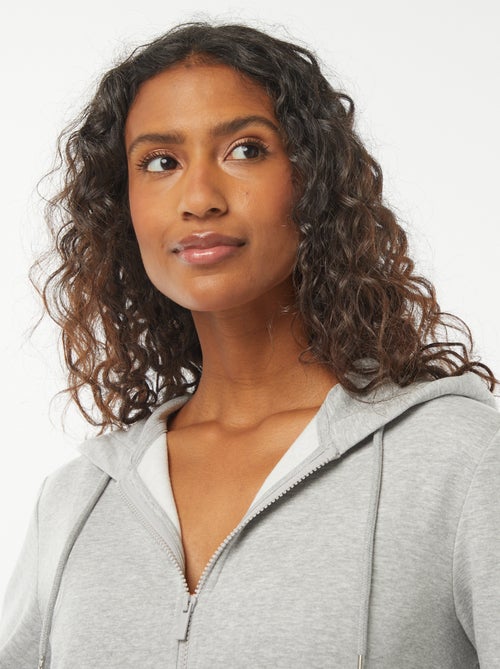 Damesvest van sweatstof met rits en capuchon - Kiabi Damesvest van sweatstof met rits en capuchon - Kiabi